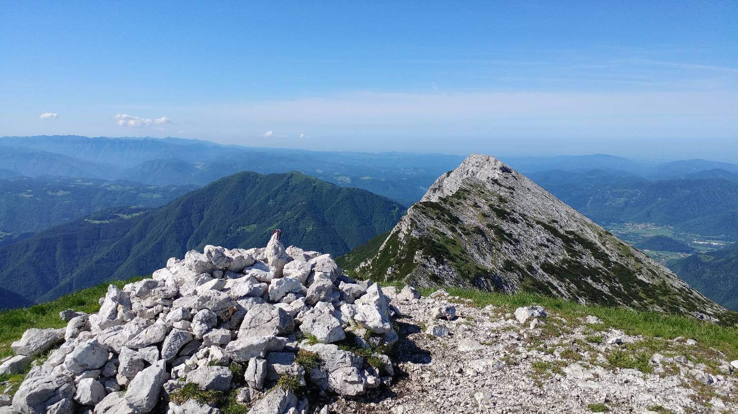 Kamnita gomila na vrhu Vogla s pogledom na Julijske Alpe